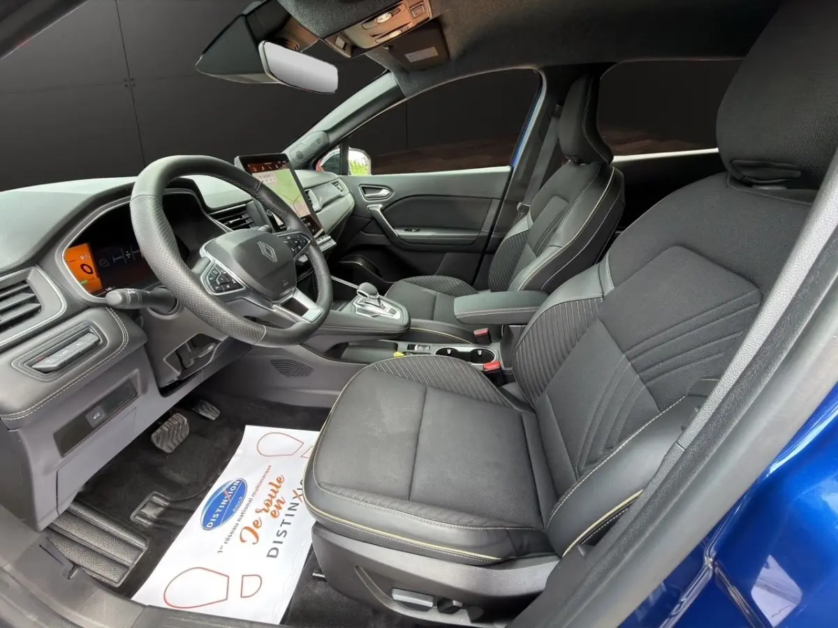 Vue intérieure côté conducteur de la Renault Symbioz Iconic E-Tech bleu, avec sièges noirs et tableau de bord digital.
