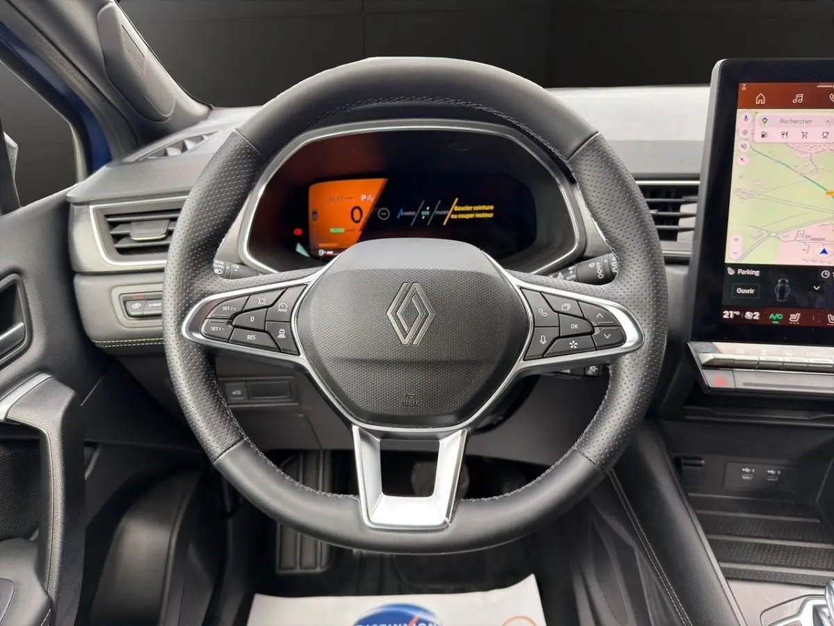 Vue rapprochée du volant noir en cuir avec commandes multifonctions et tableau de bord numérique du Renault Symbioz.