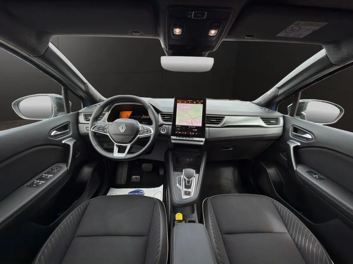Vue intérieure avant du Renault Symbioz bleu 2025, tableau de bord moderne avec écran tactile vertical central et volant multifonctions.