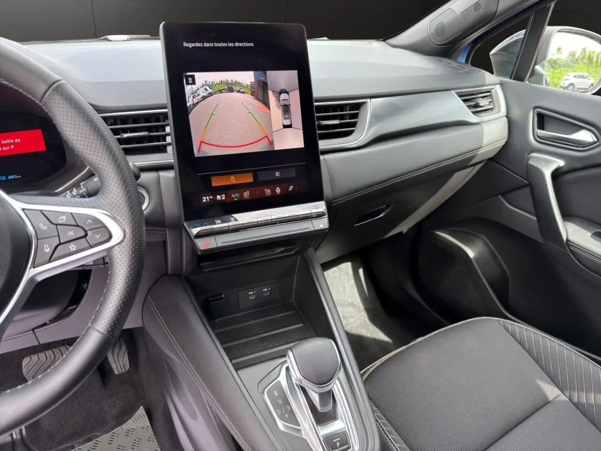 Intérieur Renault Symbioz bleu, vue côté passager montrant écran tactile central et levier de boîte automatique.