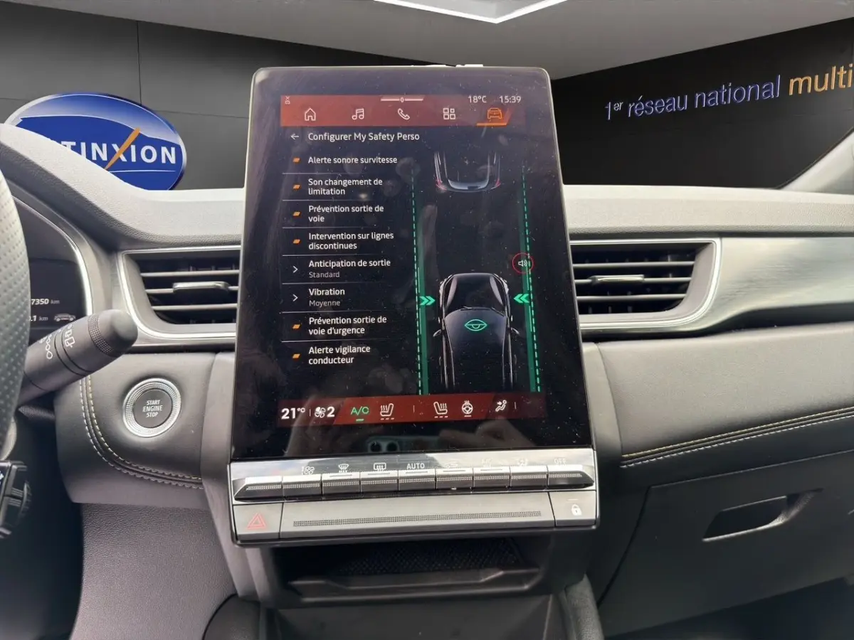 Vue intérieure du tableau de bord de la Renault Symbioz bleu, avec écran tactile central affichant les aides à la conduite.