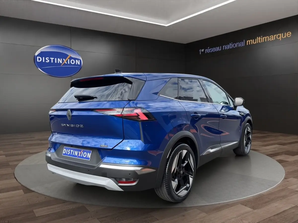 Vue 3/4 arrière droite d'un Renault Symbioz bleu avec feux arrière LED et jantes noires distinctives.