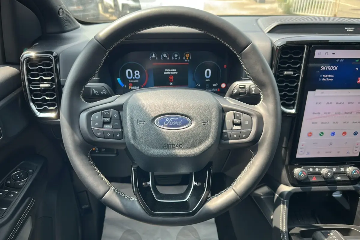 Vue centrée sur le volant cuir multifonctions du Ford Ranger 2026 avec tableau de bord numérique et écran tactile.