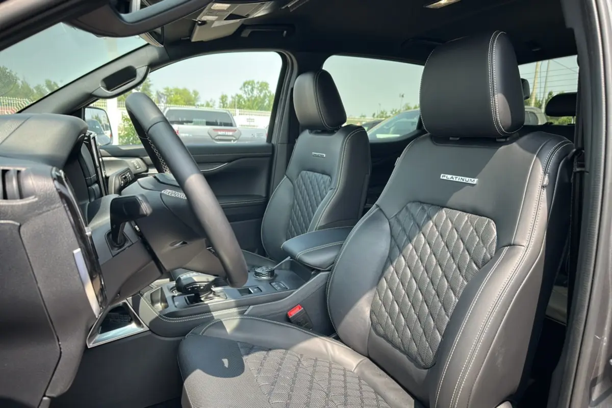 Vue intérieure côté conducteur du Ford Ranger 3.0 V6 Platinum avec sièges cuir noirs matelassés et logo Platinum brodé.