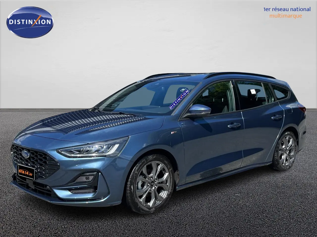 Ford Focus SW bleu en 3/4 avant droit, break ST Line X avec jantes alliage et calandre noire distinctive.