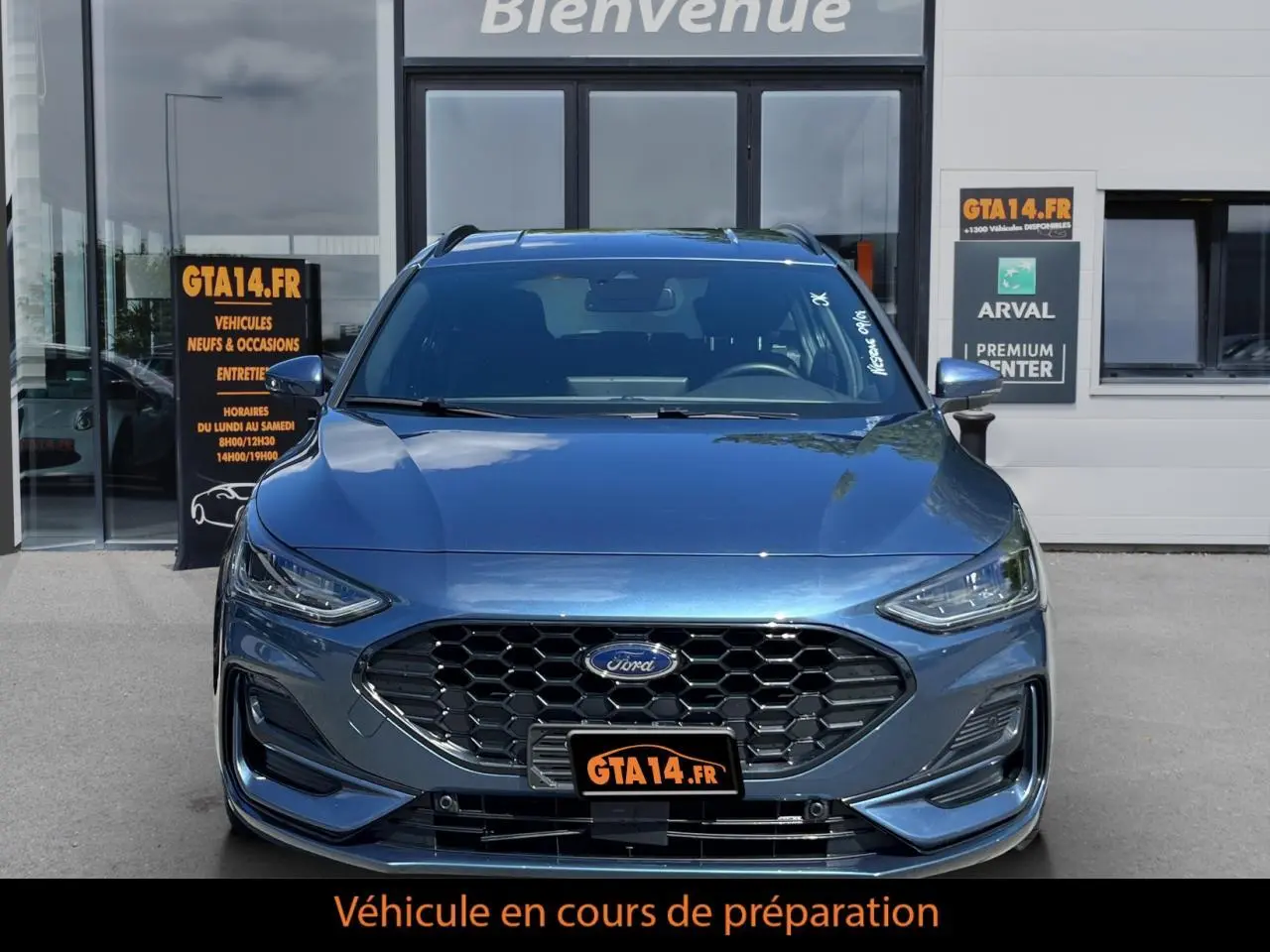Vue frontale d'une Ford Focus SW 2025 bleu métallisé avec calandre hexagonale et logo Ford visible.