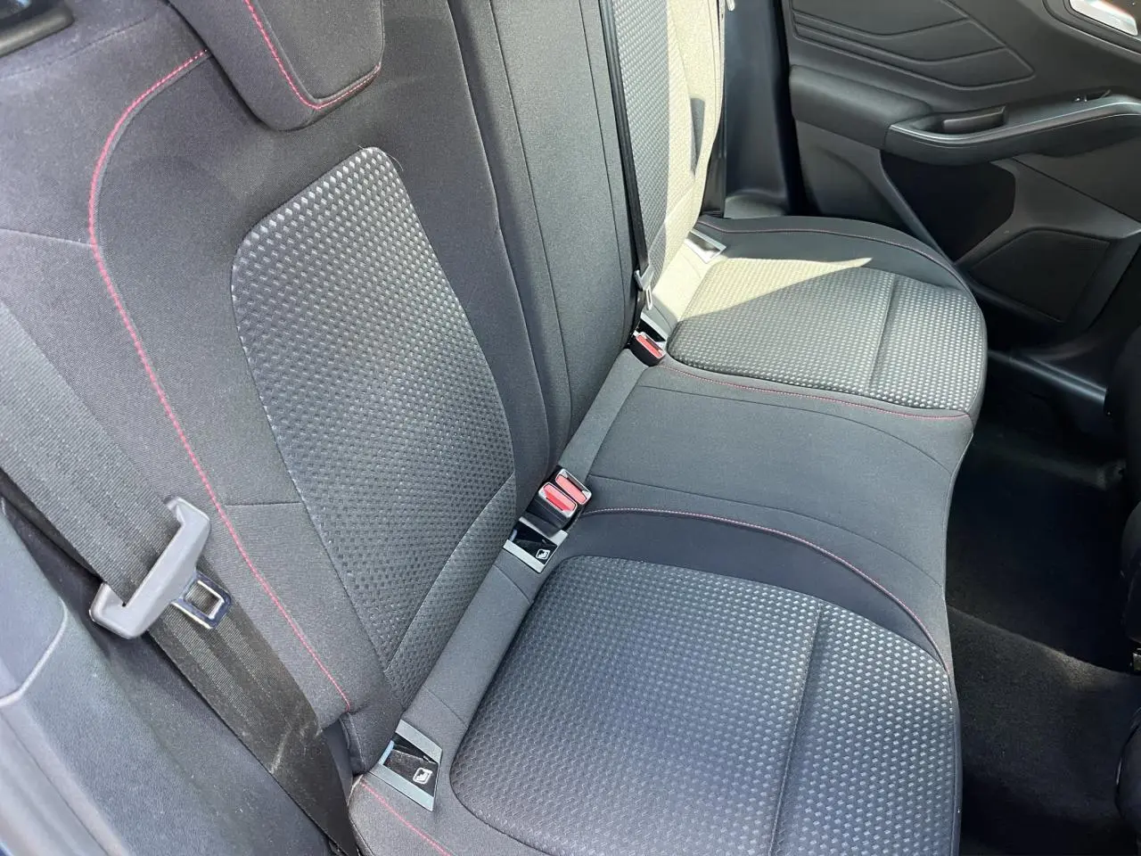 Vue intérieure des sièges arrière en tissu noir avec surpiqûres rouges d'une Ford Focus SW 2025, côté droit visible.