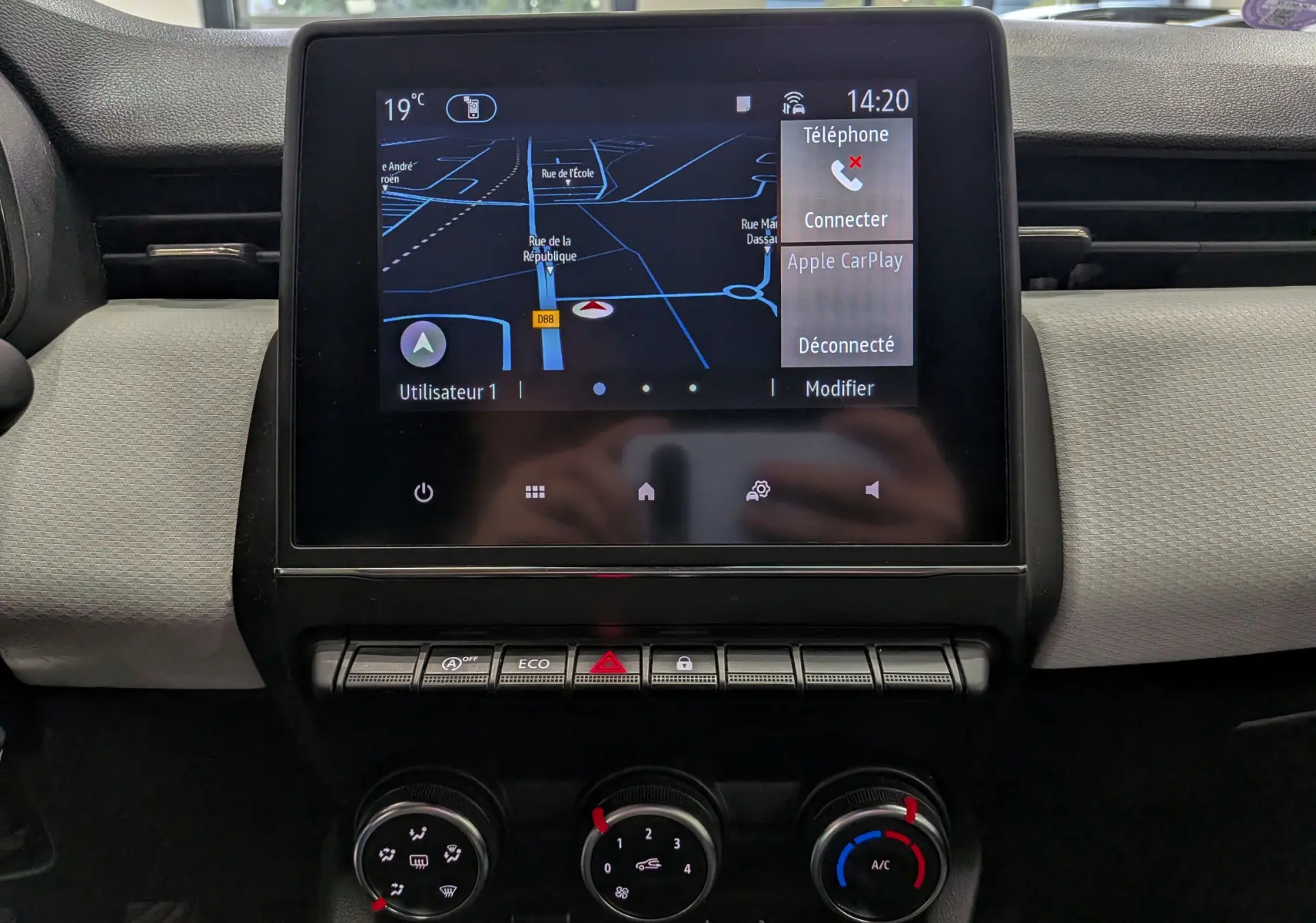 Vue rapprochée de l’écran tactile central de la Renault Clio V blanc Glacier, affichant la navigation et options connectivité.