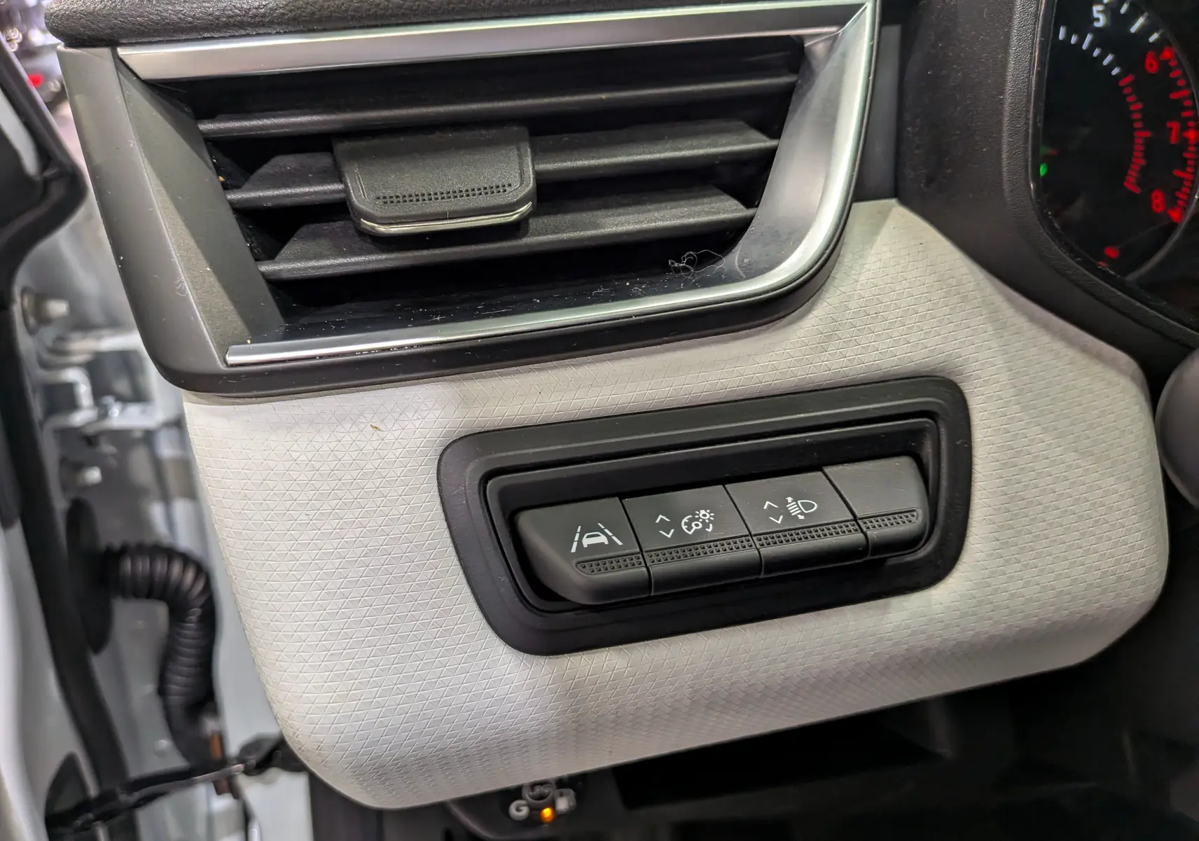 Détail intérieur côté gauche du tableau de bord blanc glacier de la Renault Clio V avec commandes d'assistance à la conduite.