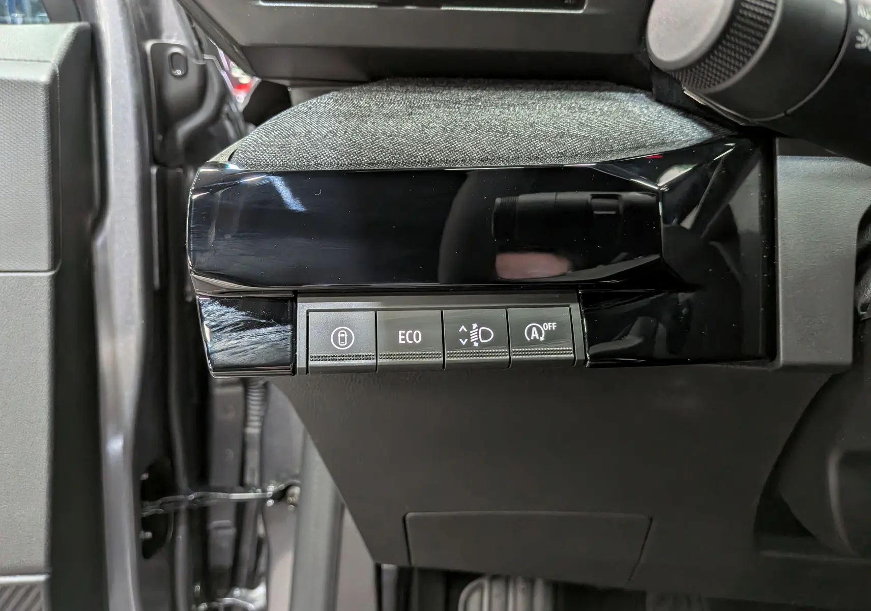 Vue rapprochée des commandes côté gauche du tableau de bord d’une Renault Clio VI gris schiste, boutons ECO et aides à la conduite.