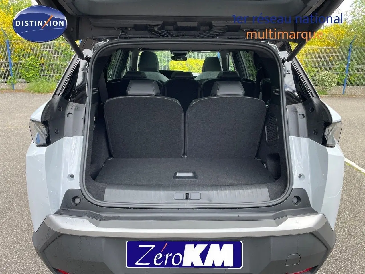 Vue arrière ouverte du Peugeot 5008 blanc Okenite métal avec toit noir, montrant l'espace de coffre et les sièges arrière.