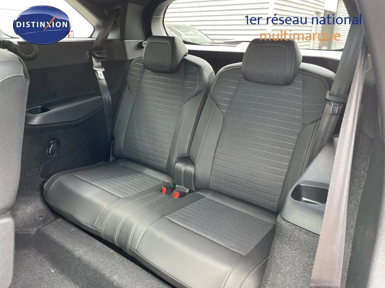 Vue intérieure sur la troisième rangée de sièges en cuir noir du Peugeot 5008 Hybrid 2025, avec ceintures visibles.