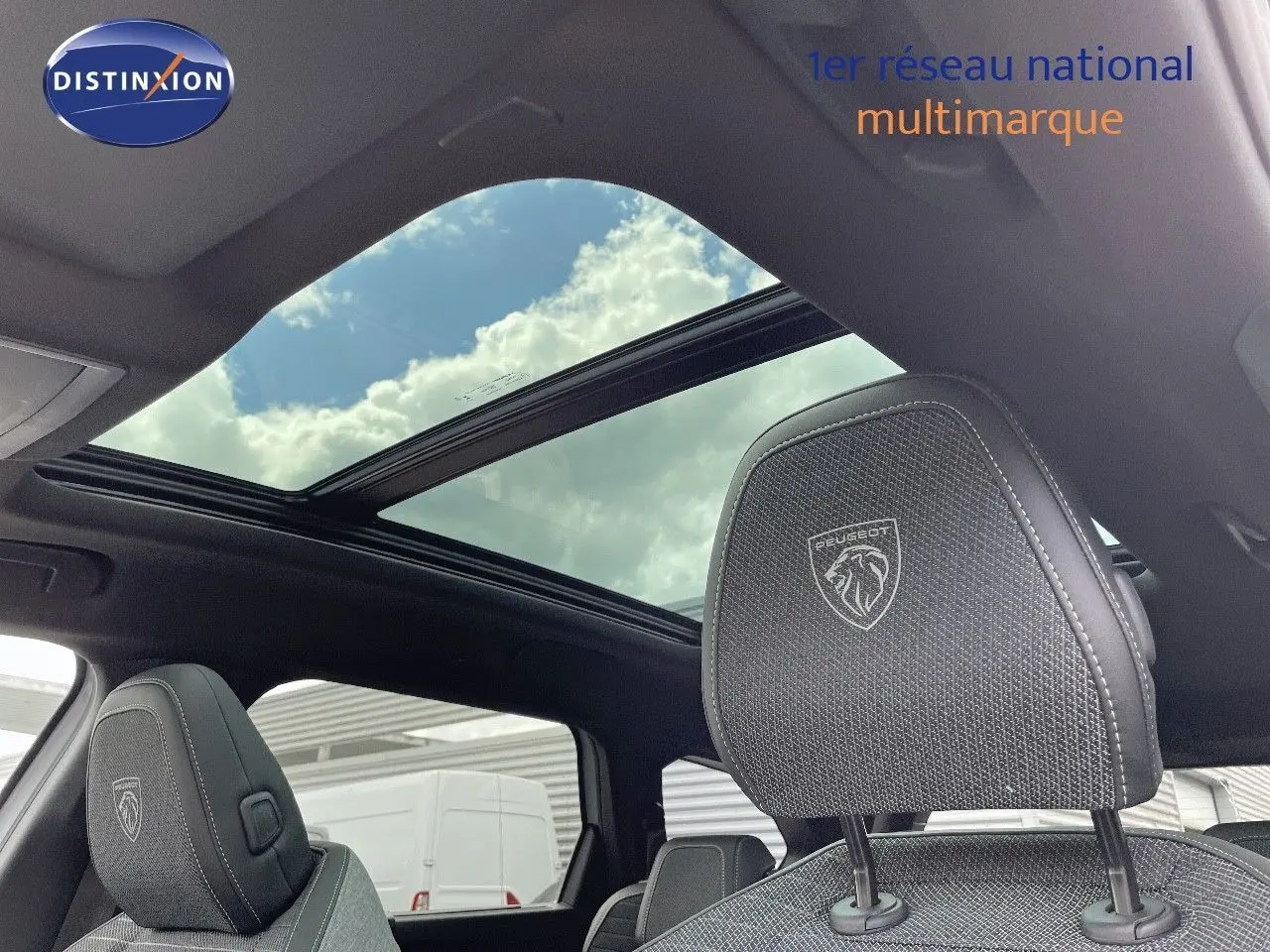 Vue intérieure du Peugeot 5008 Hybrid 136ch GT 2025, toit panoramique et appuie-tête avant brodé logo Peugeot.