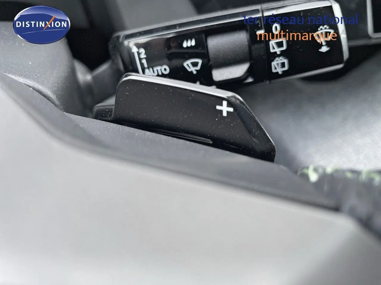Gros plan sur le levier de vitesses automatique avec palettes au volant du Peugeot 5008 Hybrid blanc et toit noir.