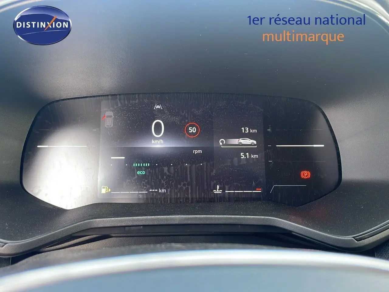 Vue rapprochée du tableau de bord numérique de la Renault Clio 1.5 DCI gris schiste métal avec affichage d'informations de conduite.