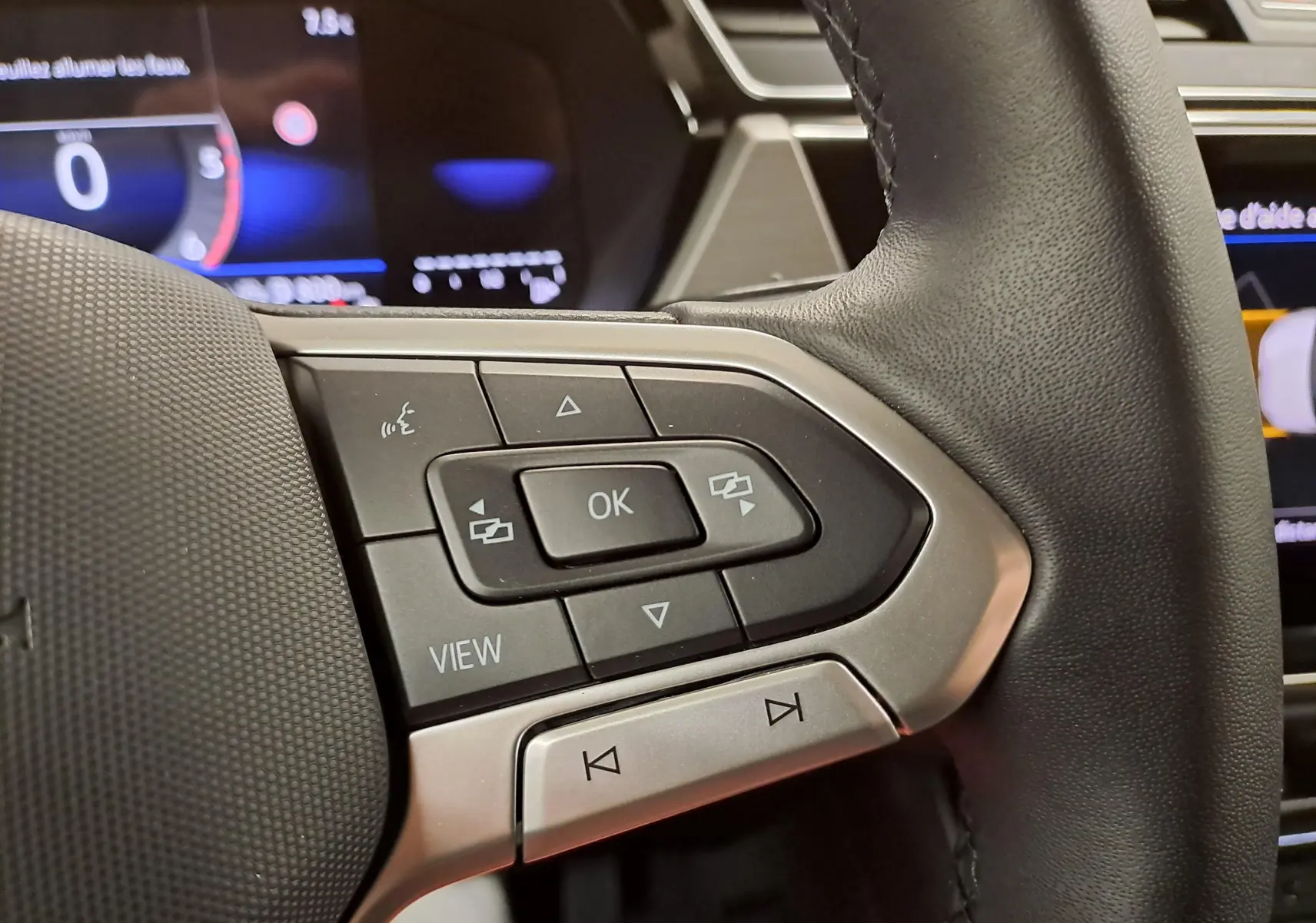Gros plan sur les commandes multifonctions à gauche du volant du Volkswagen Touran 2025, finition VW Edition.