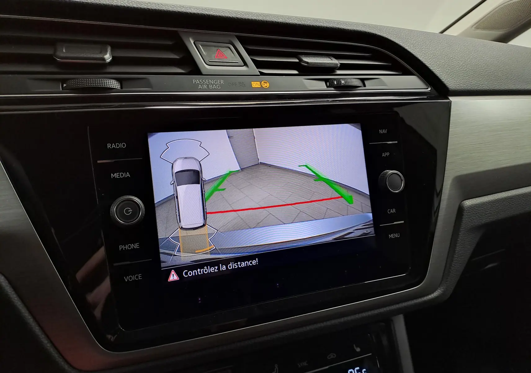 Écran central du Volkswagen Touran 2025 affichant la caméra de recul avec guidage vert et rouge, intérieur noir.