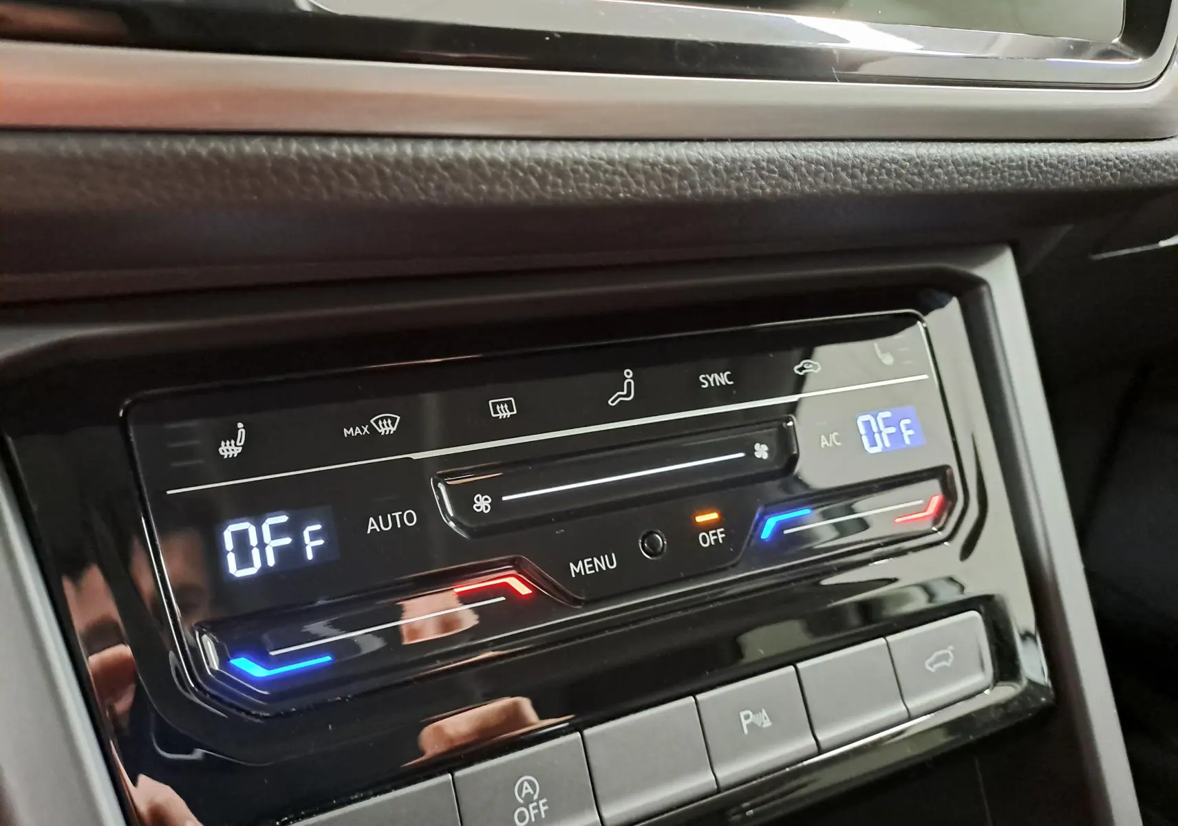 Gros plan sur la commande de climatisation digitale du Volkswagen Touran 2025, avec affichage des réglages et boutons tactiles.