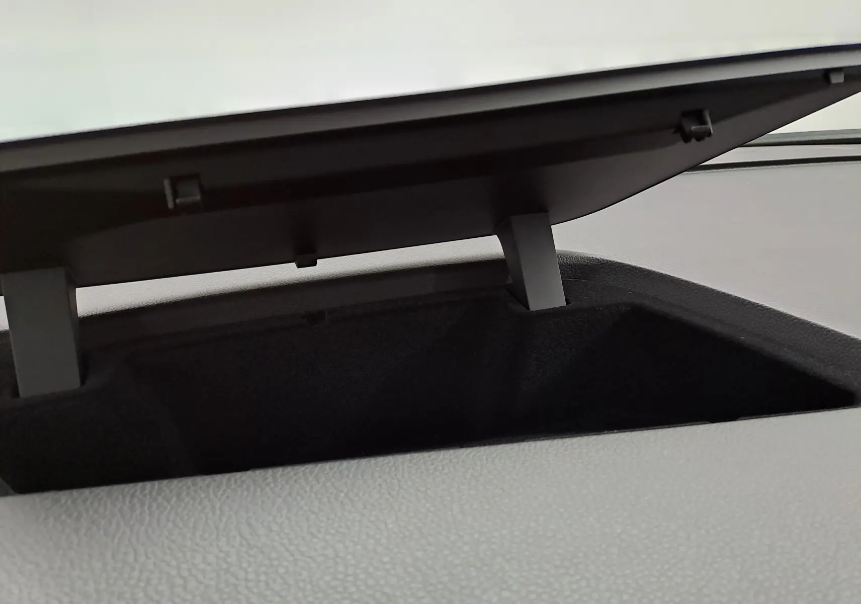 Coffre de rangement ouvert sur le tableau de bord du Volkswagen Touran 2025 en Argent Dolomite, vue intérieure rapprochée.