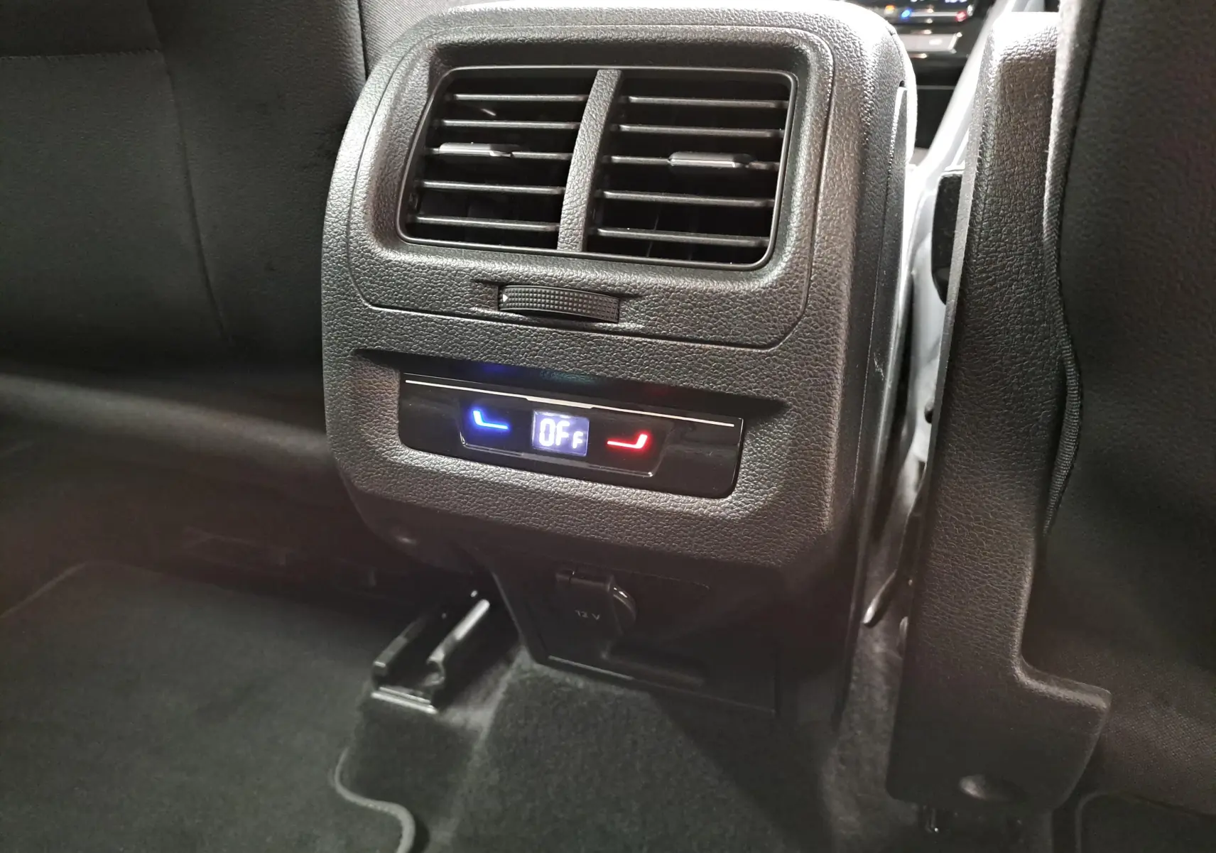 Vue rapprochée de la console arrière noire avec ventilation et commandes climatisation du Volkswagen Touran 2025.