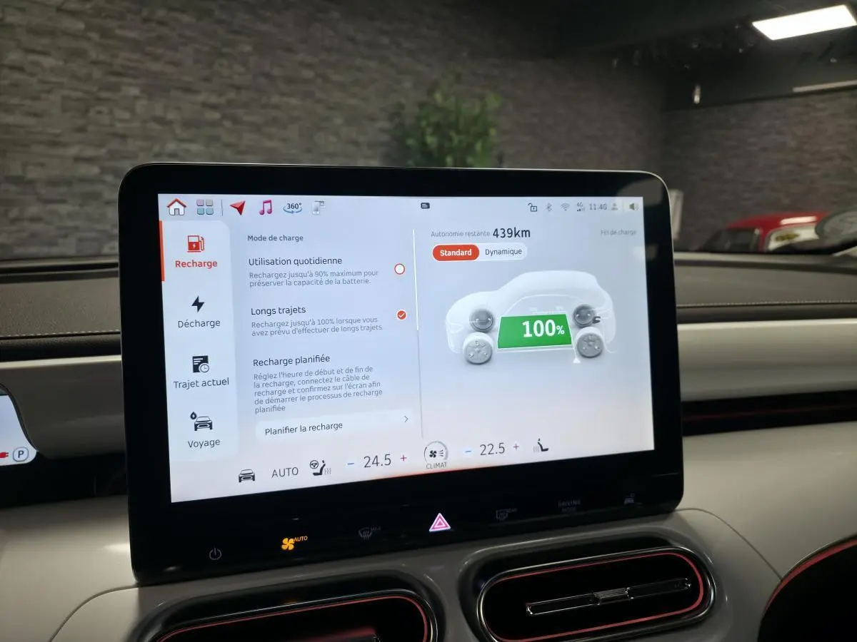 Écran tactile central du tableau de bord d'une Smart Electric blanche, affichant la recharge à 100% et 439 km d'autonomie.