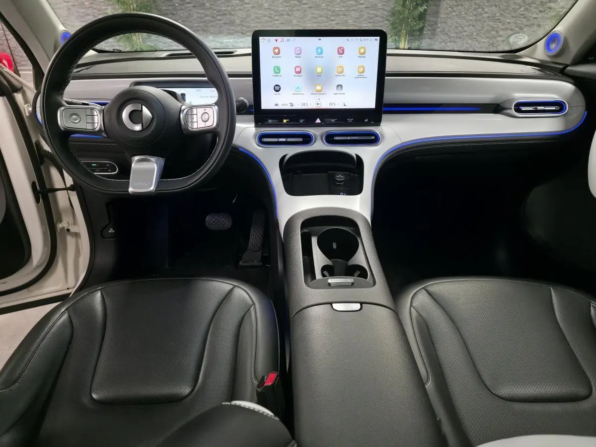 Vue intérieure avant du Smart #1 électrique blanc 2024, avec tableau de bord moderne et écran tactile central lumineux.