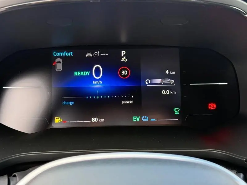 Tableau de bord numérique du Renault Captur 2025 affichant la vitesse à 0 km/h et l'autonomie hybride en mode confort.