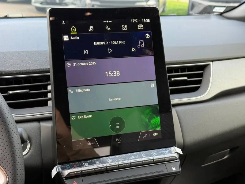 Écran tactile central du tableau de bord du Renault Captur 2025, affichant radio, téléphone et score écologique.