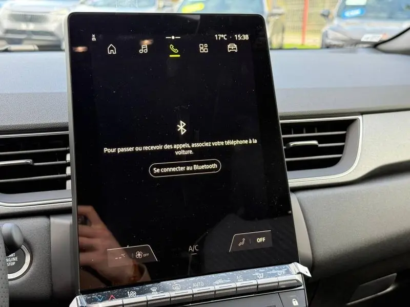 Écran tactile central du tableau de bord du Renault Captur 2025, affichant la connexion Bluetooth, intérieur gris.