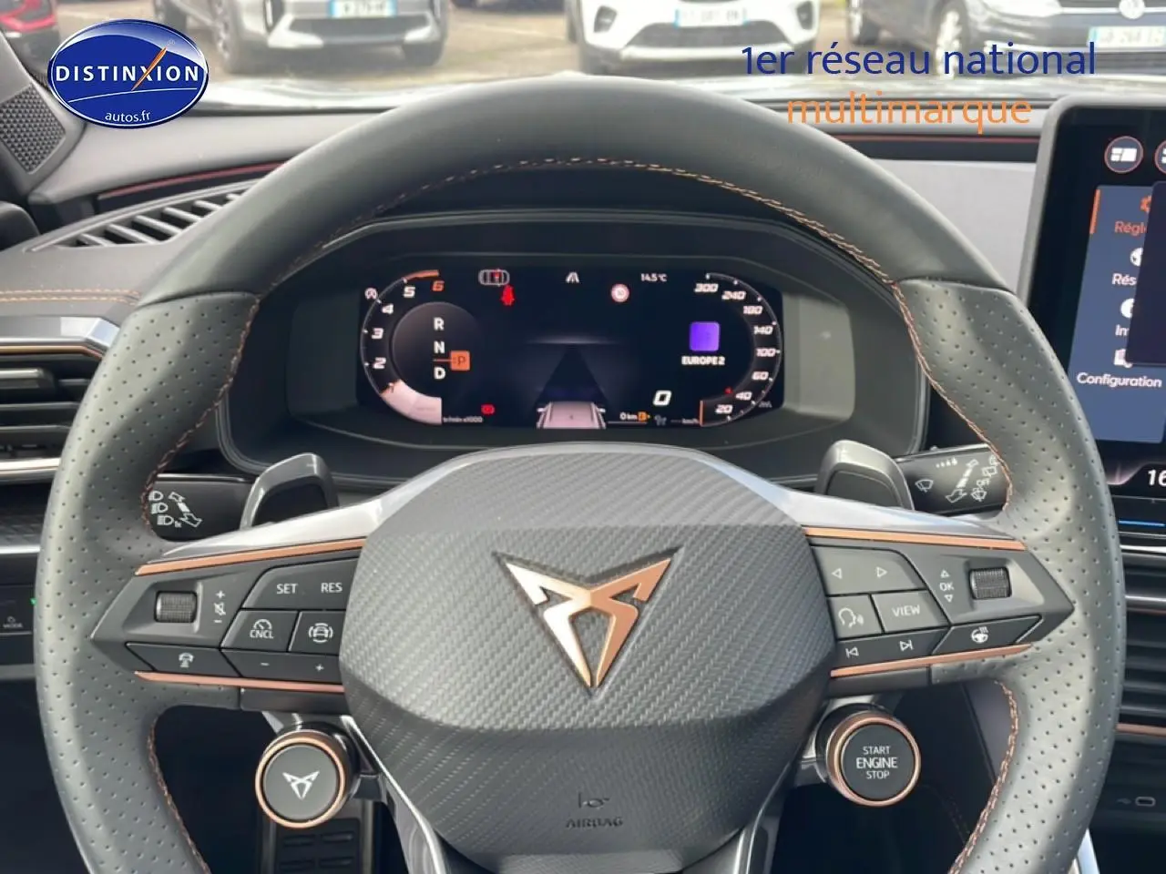 Volant sport en cuir perforé avec logo CUPRA, vue de face sur tableau de bord numérique et commandes intégrées.