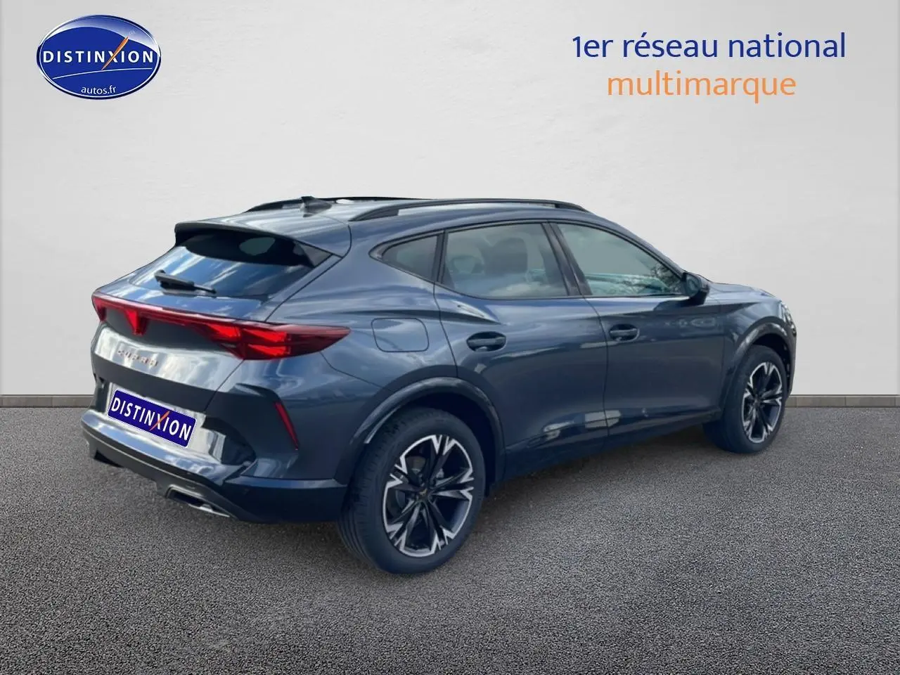 Vue 3/4 arrière droite d'un CUPRA Formentor gris magnétique avec jantes noires et feux arrière LED allumés.