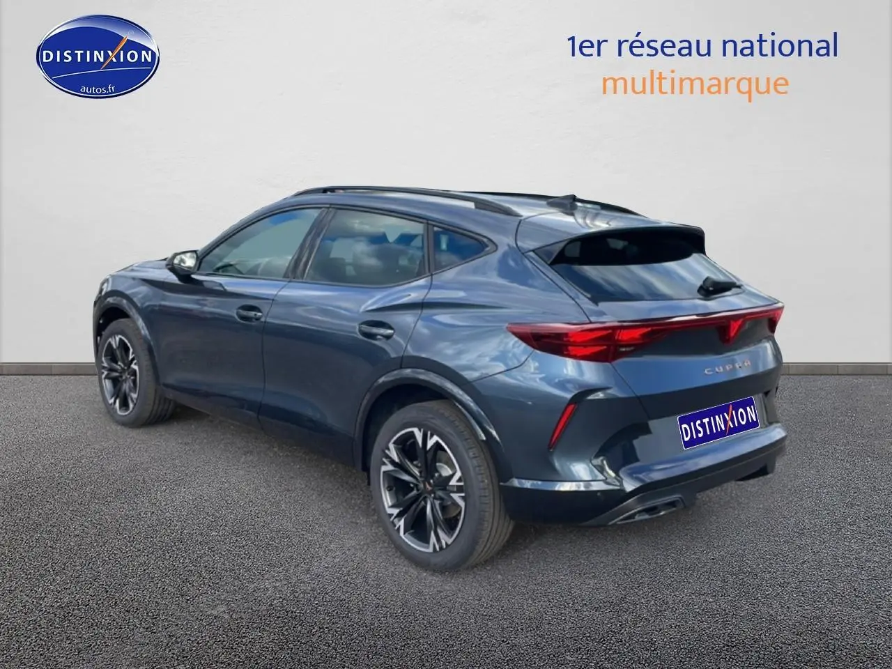 Vue 3/4 arrière droite du CUPRA Formentor gris magnétique avec jantes 18 pouces et feux arrière LED allumés.