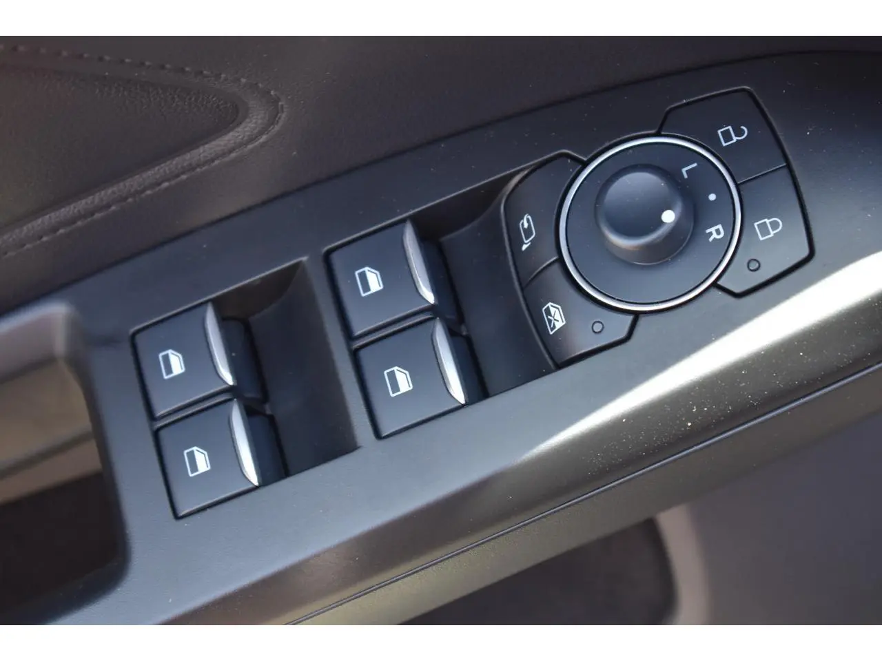 Gros plan sur les commandes des vitres et des rétroviseurs côté conducteur de la Ford Focus SW 2025 finition ST LINE X.