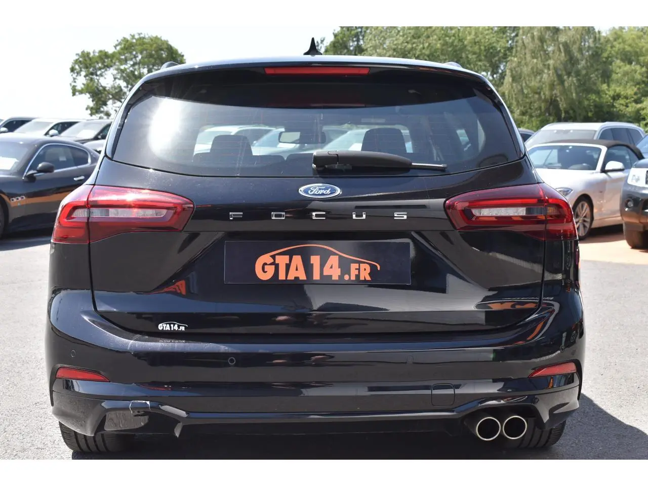 Vue arrière d'une Ford Focus SW 2025 Agate Black Metallic avec double sortie d'échappement et feux LED distinctifs.