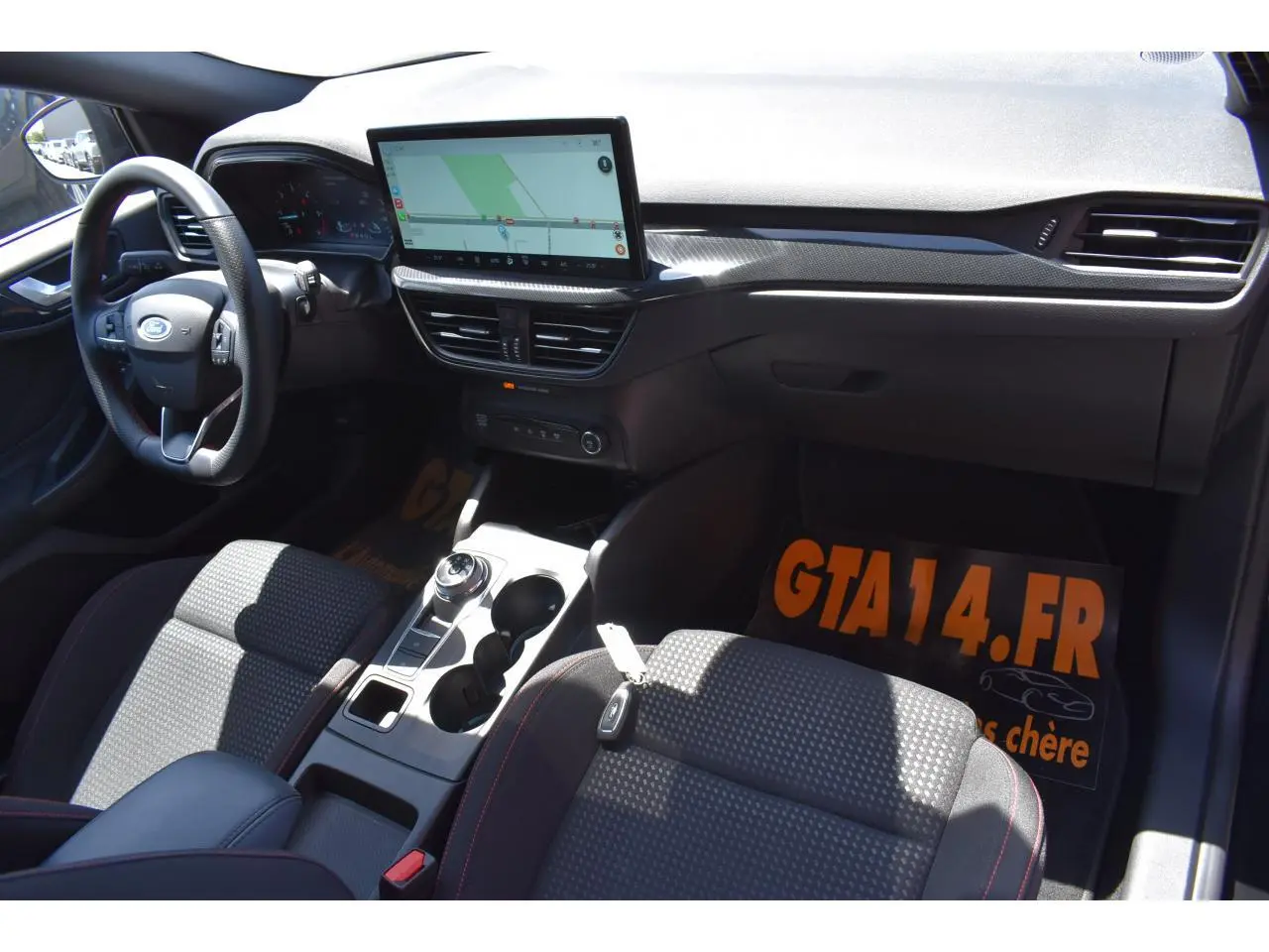 Vue intérieure avant droite de la Ford Focus SW 1.5 EcoBlue 115 ST LINE X avec écran tactile et volant multifonction.