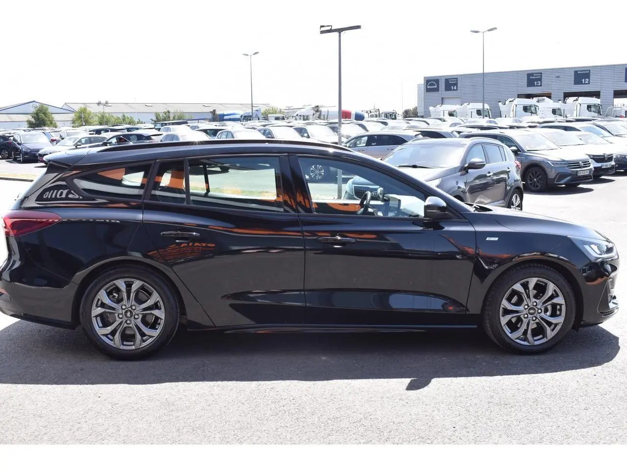 Vue latérale gauche d'une Ford Focus SW 2025 Agate Black Metallic avec jantes alliage et vitres teintées.