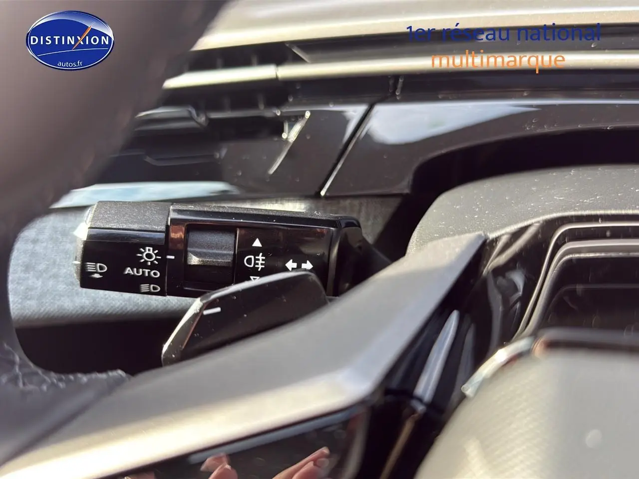 Gros plan sur la commande des phares automatiques à gauche du volant du Peugeot 3008 gris titane 2025.