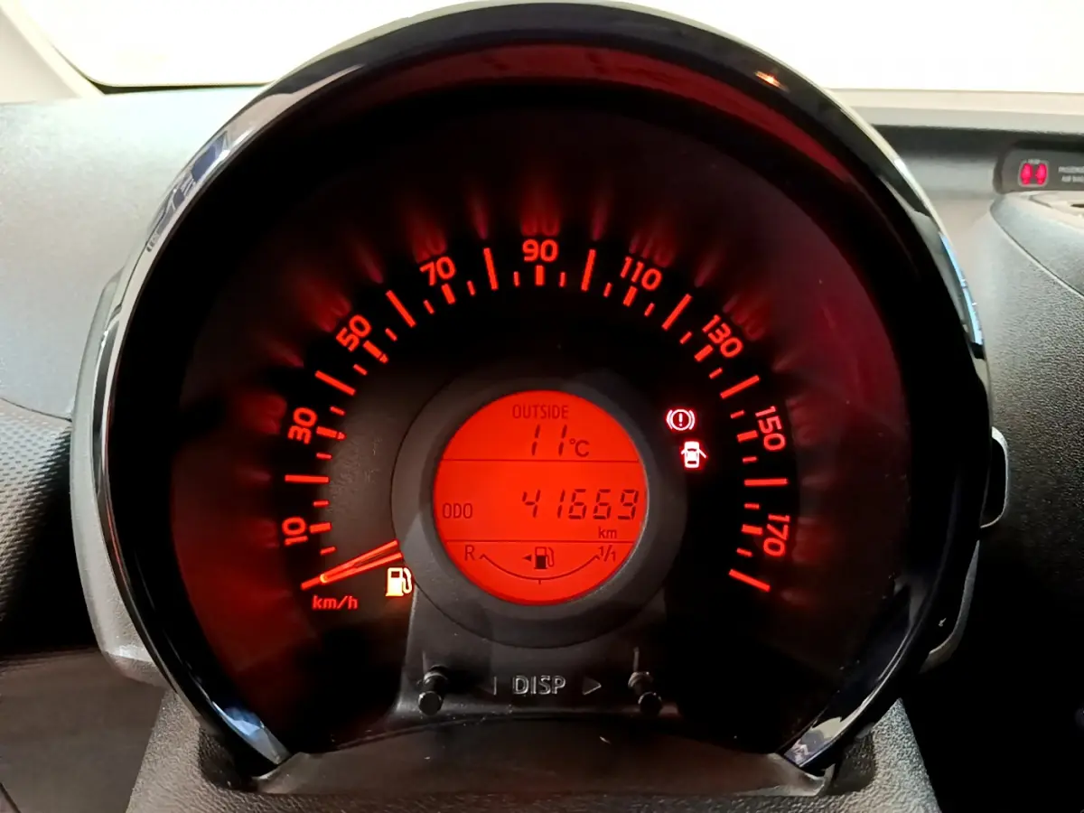 Vue rapprochée du compteur de vitesse rouge de la Citroën C1 blanche, affichant 41669 km et 11°C extérieur.