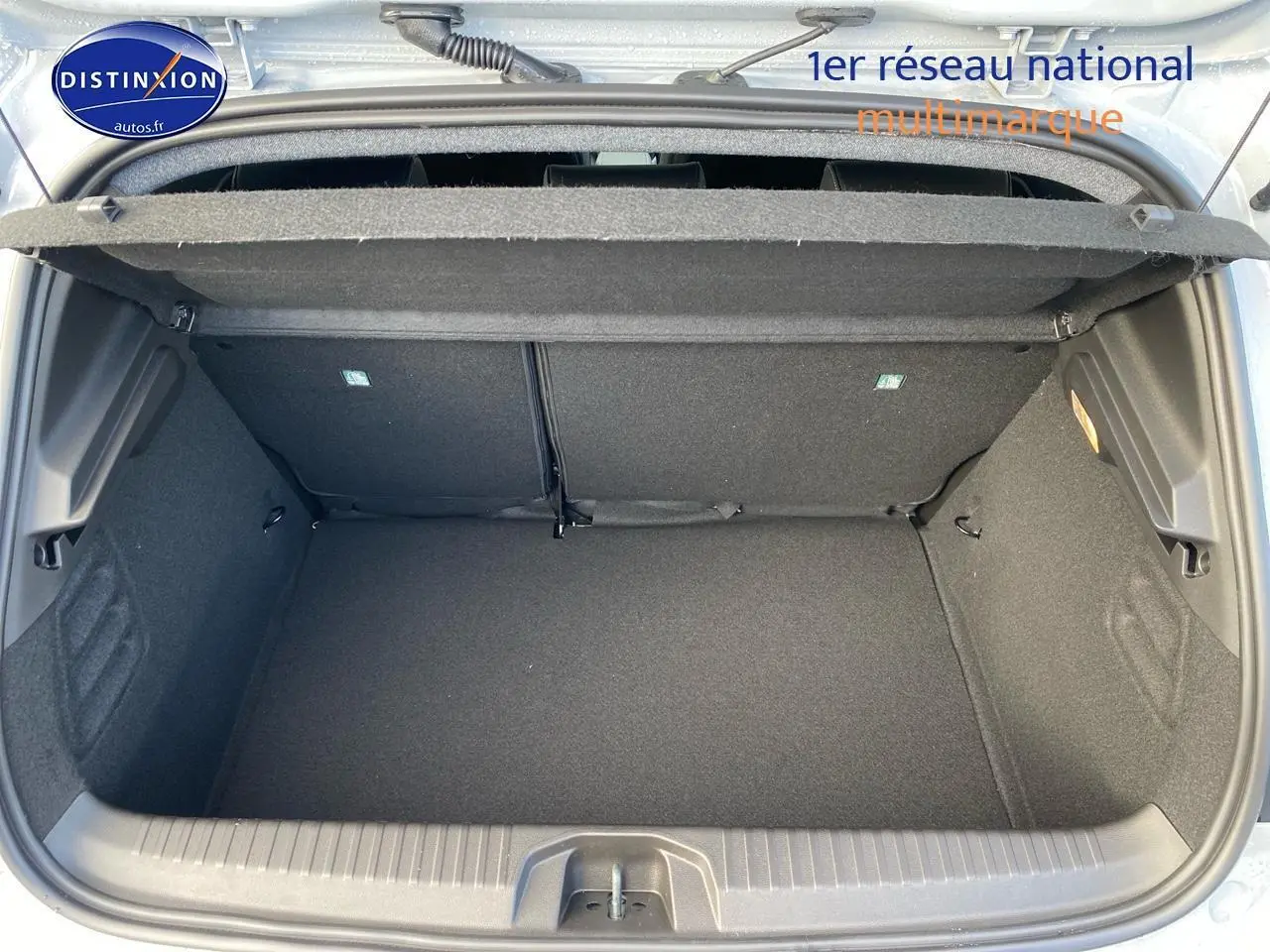 Coffre ouvert vu de dessus d’une Renault Clio V gris rafale, montrant un espace de rangement vide et propre.
