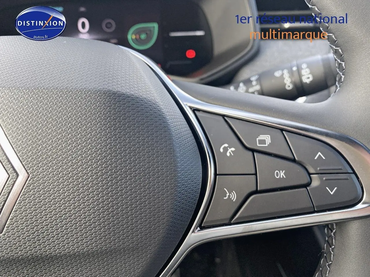 Gros plan sur le volant multifonction de la Renault Clio V, avec commandes audio et téléphone intégrées.
