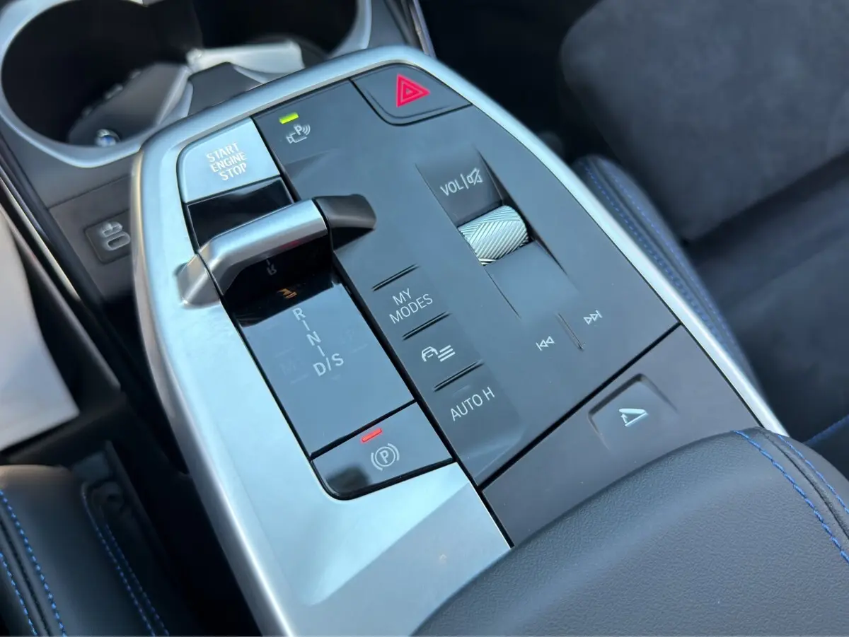 Gros plan sur la console centrale noire et argentée du BMW X1 sDrive20d 2025 avec levier de vitesses et commandes tactiles.