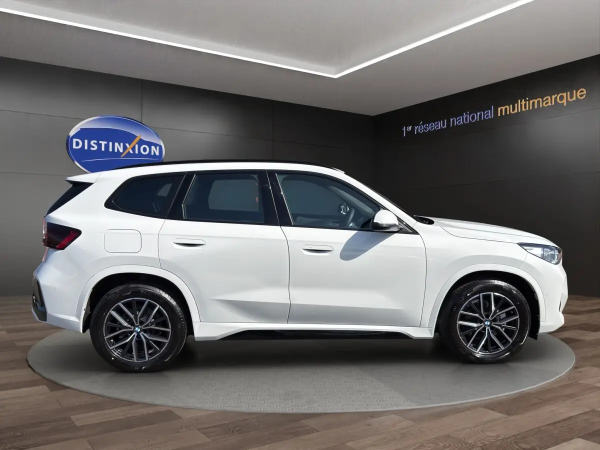 BMW X1 sDrive20d blanc vue de profil côté gauche avec jantes alliage et toit noir contrasté