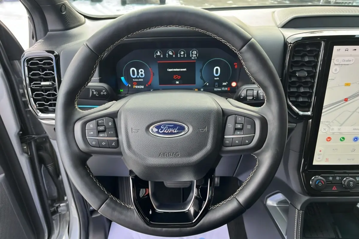 Vue intérieure centrée sur le volant cuir noir avec commandes multifonctions du Ford Ranger gris iconic 2026.