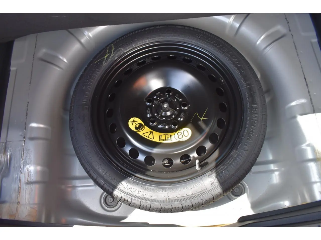 Gros plan sur la roue de secours galette 16 pouces dans le coffre d'une Ford Focus SW 2025 Moondust Silver.