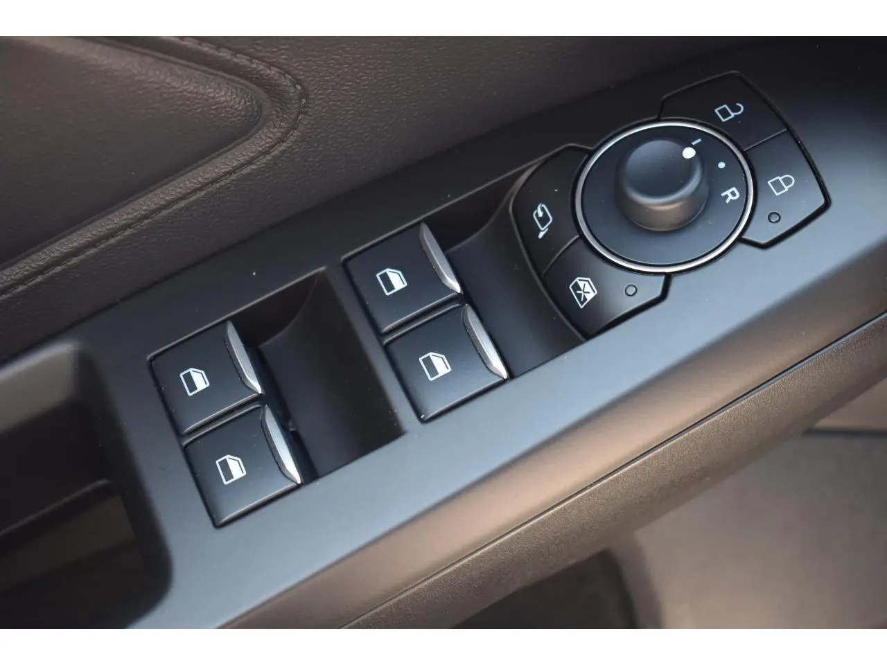 Gros plan sur les commandes de lève-vitres et rétroviseurs sur la portière côté conducteur de la Ford Focus SW 2025.