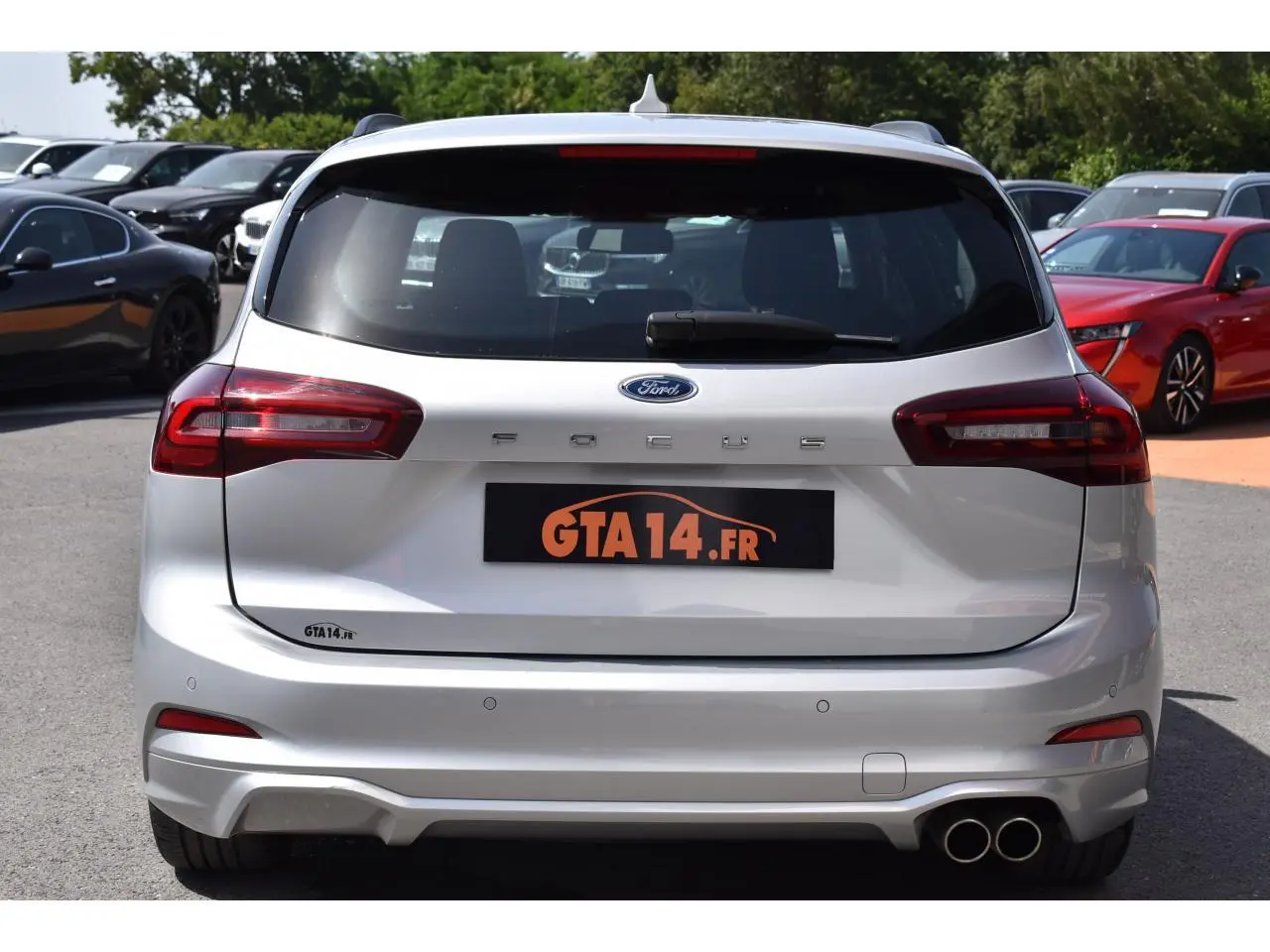 Vue arrière d'une Ford Focus SW 2025 Moondust Silver avec feux LED et double sortie d'échappement chromée.