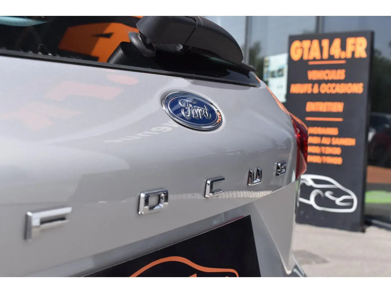 Gros plan sur l'arrière droit d'une Ford Focus SW Moondust Silver avec logo et sigle visibles.