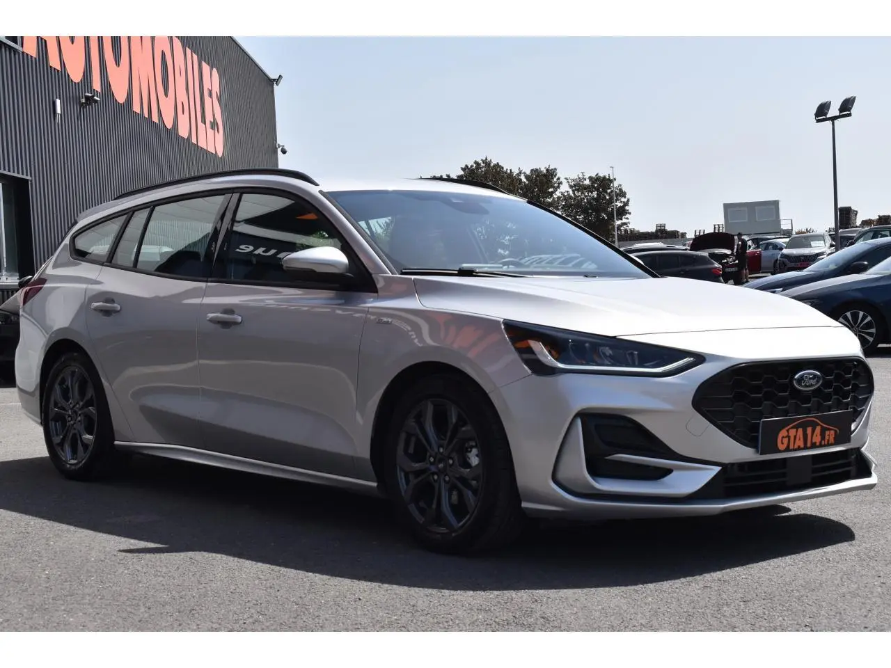 Ford Focus SW 2025 Moondust Silver vue 3/4 avant droit, jantes alliage noires et calandre noire hexagonale.