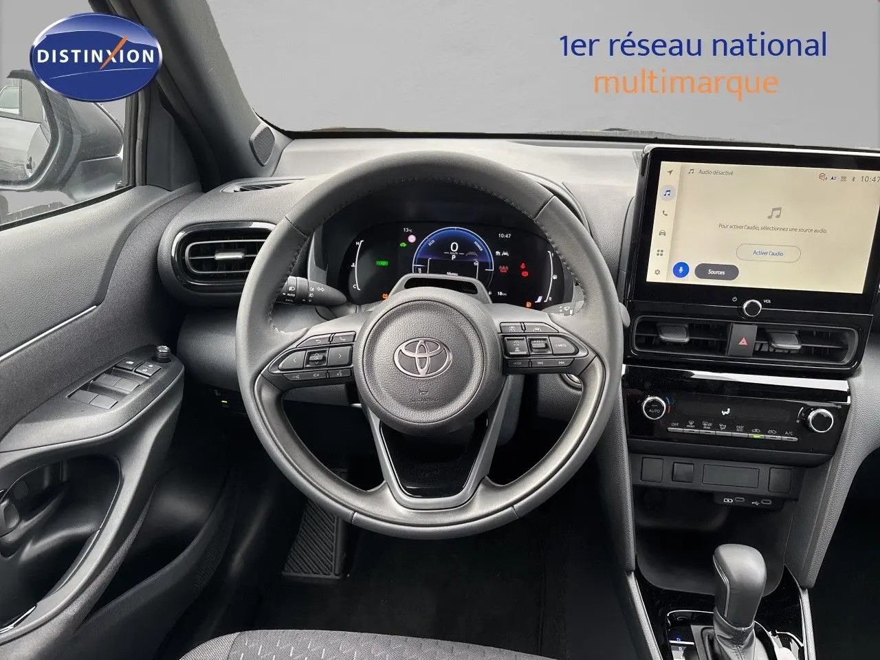 Vue intérieure centrée sur le volant et tableau de bord de la Toyota Yaris Cross hybride, avec écran tactile et finition noire.