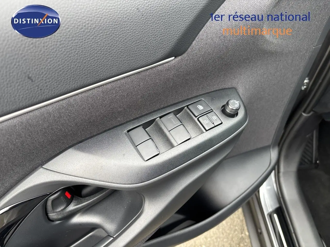 Détail de la porte avant gauche de la Toyota Yaris Cross gris atlas métal, avec commandes des vitres et rétroviseurs.